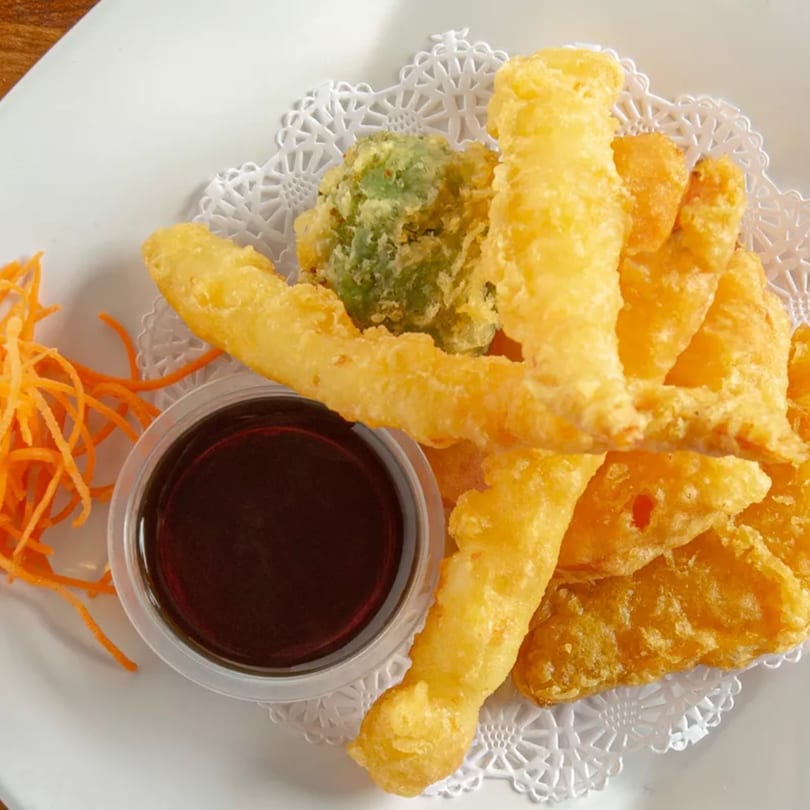 Aiki Sushi & Ramen's tempura platter with shrimp, vegetables, shredded carrots, and dipping sauce.