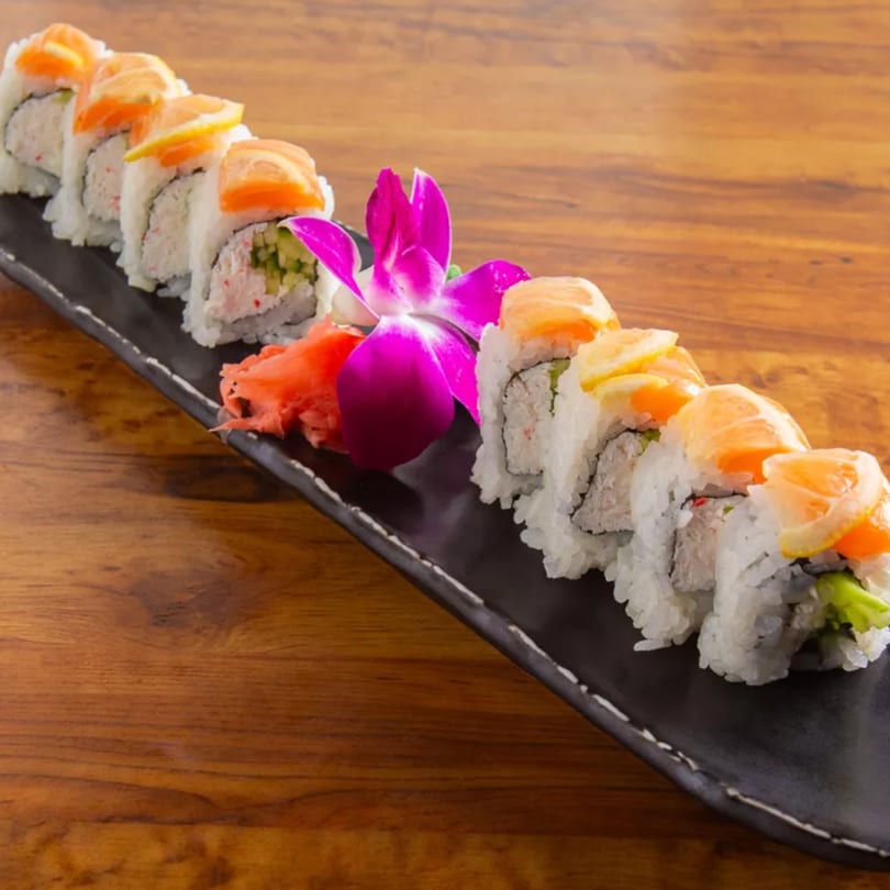 Aiki Sushi & Ramen's salmon and lemon sushi roll with ginger and a purple orchid.